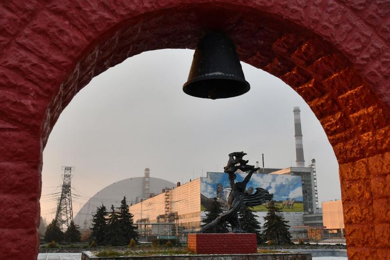 A monument in front of the giant protective dome built over the sarcophagus of the destroyed fourth reactor of Chernobyl nuclear power plant. AFP