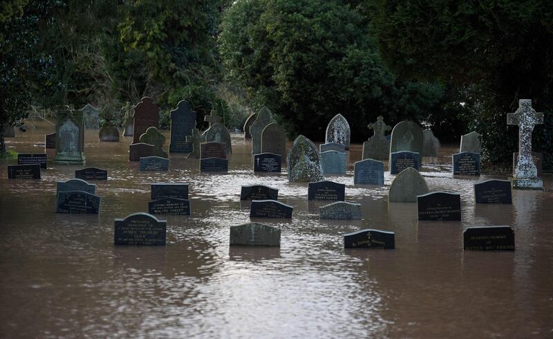 Flood water surrounds grave stones in a graveyard in Tenbury Wells, after the River Teme burst its banks in western England.  AFP