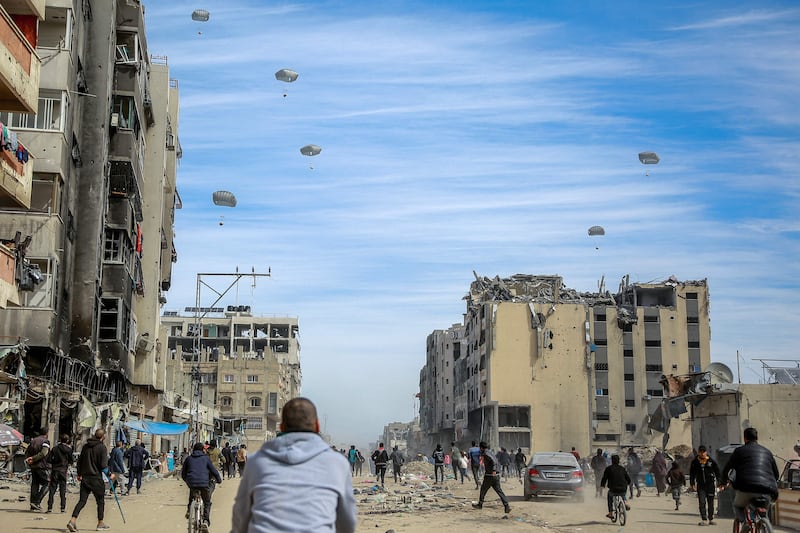 Palestinians rush to collect an aid air drop in Gaza city, amid reports that many people in the enclave face starvation after months of Israeli attacks. AFP