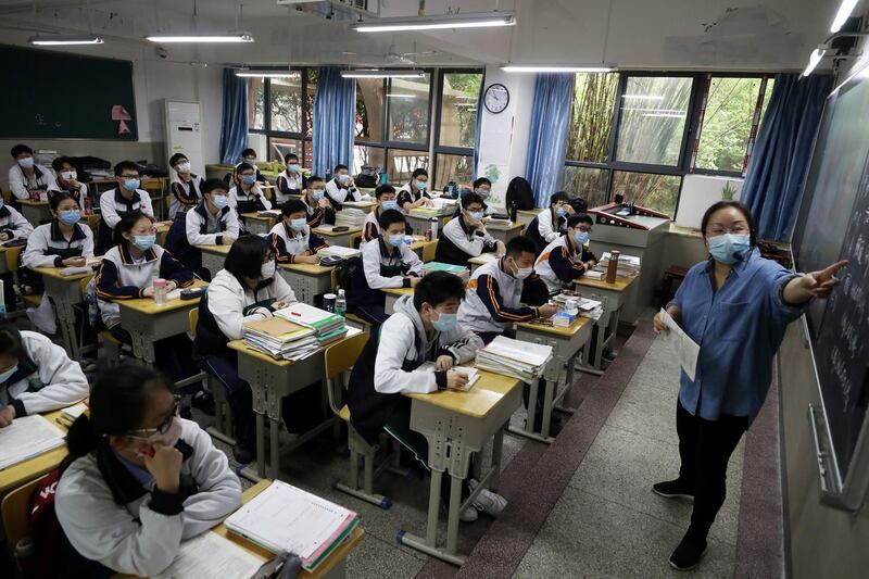A teacher and senior high school pupils wearing face masks are seen inside a classroom on their first day of returning to school in Wuhan, Hubei province, China.  Reuters