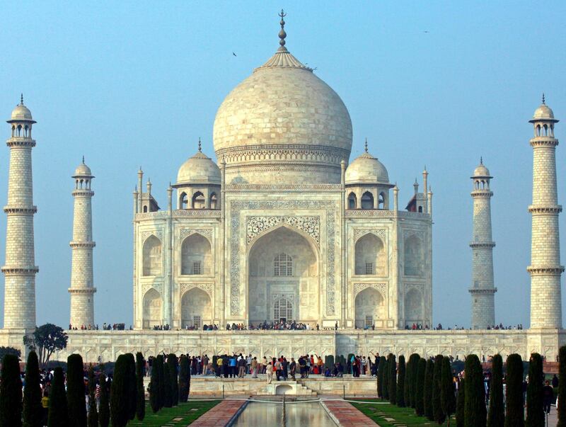 Tourists stand in front of the historic Taj Mahal in the northern Indian city of Agra January 17, 2009. The Taj Mahal was built by Emperor Shah Jahan in memory of his wife and is one of the world's most famous monuments. REUTERS/Vijay Mathur (INDIA) - GM1E51I0E5W01