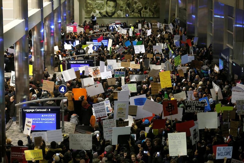 Hundreds of people rally against the travel ban signed by Donald Trump during a protest at the baggage claim area of a Detroit airport. The ban has been welcomed by some hardliners inside Iran, which is one of the countries affected Rebecca Cook / Reuters