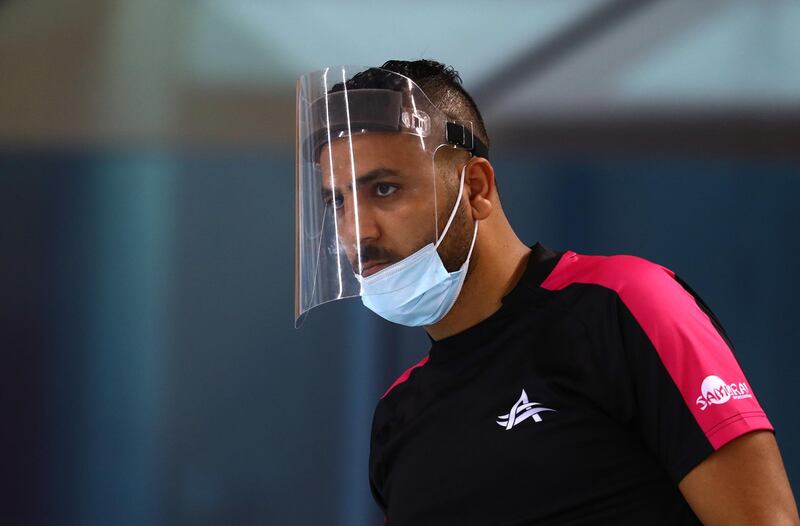 A swimming coach wearing a plastic face visor is seen at Hamdan Sports Complex. Getty Images