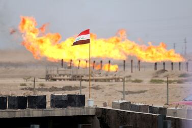 A flag flying in front of excess gas being burnt off at a pipeline south-west of Basra in southern Iraq. AFP