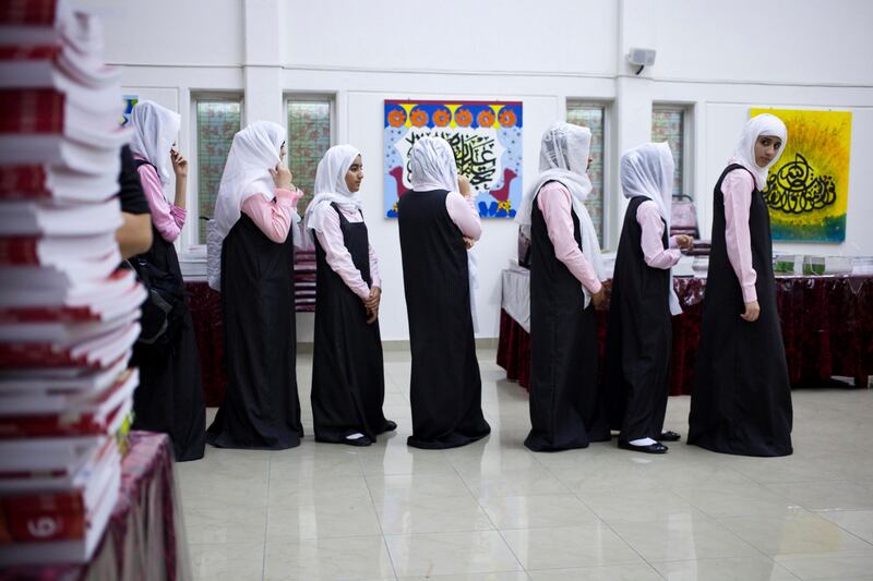 Ras Al Khaimah, United Arab Emirates - September 9 2012 - Students at the Queeba Girls School in Ras Al Khaimah queue to receive their school books for the year. (Razan Alzayani / The National) 