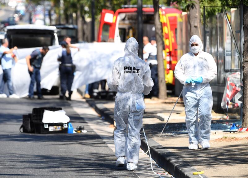 A white sheet is erected as a body of a victim is evacuated to a waiting ambulance while French forensic police officer searches the site following a car crash on August 21, 2017, in the southern Mediterranean city of Marseille.  
At least one person has died in Marseille after a car crashed into people waiting at two different bus stops in the southern French port city, police sources told AFP, adding that the suspected driver had been arrested afterwards. The police sources, who asked not to be identified, did not say whether the incident was being treated as a terror attack or an accident.  / AFP PHOTO / boris HORVAT