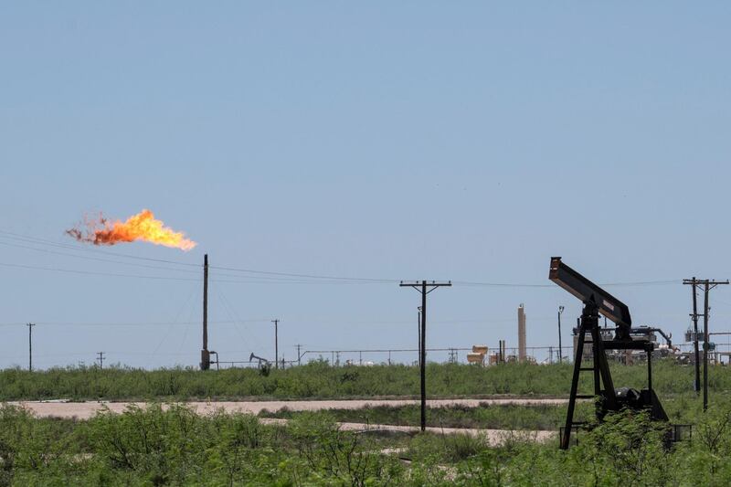 (FILES) In this file photo a flare stack is pictured next to pump jacks and other oil and gas infrastructure on April 24, 2020 near Odessa, Texas. Malfunctioning equipment accounts for about half of the biggest sources of potent greenhouse gas methane emissions at the United States' largest oilfield, a study led by NASA showed on June 2, 2021. Researchers found that repairing just 123 sources found to leak most persistently in the area they surveyed using sensor-equipped planes would reduce methane emissions by 55 tons (50 metric tons) an hour. / AFP / Paul Ratje
