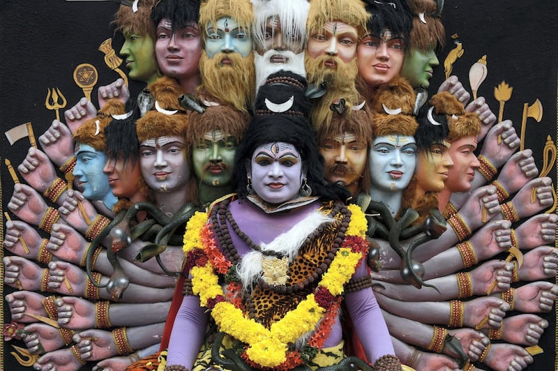 This September 6, 2017 picture shows an Indian 'Theyyam' artist posing for a photograph while performing during the 'Kummati Kali' as part of the annual Onam festival celebrations in Thrissur district of southern Kerala state. - The Theyyam worship rituals are part of several thousand year-old traditions and customs celebrated in Kerala state. (Photo by ARUN SANKAR / AFP)