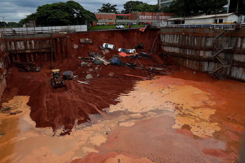 Vehicles lay at the bottom of a construction site after a road collapsed due to heavy rains in the centre of Brasilia, Brazil.  AP