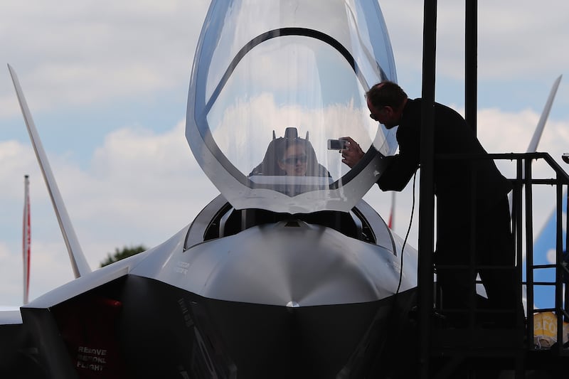 A visitor sits in a model of a Lockheed Martin F-35 Lighting stealth fighter, which was big news at Farnborough Airshow in 2014.