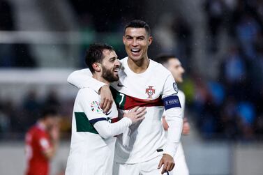 Portugal's forward Cristiano Ronaldo (R) celebrates after opening the scoring with Portugal's midfielder Bernardo Silva during the UEFA Euro 2024 group J qualification football match between Luxembourg and Portugal at the Stade de Luxembourg, in Luxembourg, on March 26, 2023.  (Photo by Kenzo TRIBOUILLARD  /  AFP)