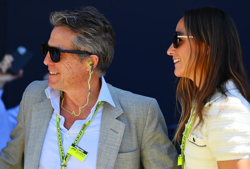 Actor Hugh Grant and Anna Elisabet Eberstein walk in the paddock. Getty