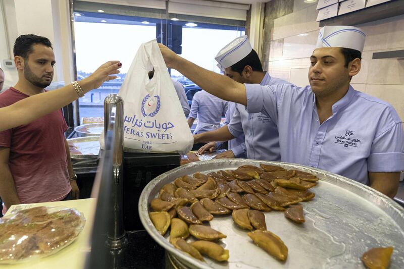 DUBAI, UNITED ARAB EMIRATES. 18 MAY 2019. RAMADAN STANDALONE. During the Holy Month of Ramadan Feras Sweets on Al Barsha 1 sells their famous Kunafa along with other delicious treats to a long queue of patients customers right before Ifatr time untill the late hours of the evening. (Photo: Antonie Robertson/The National) Journalist: None. Section: National.