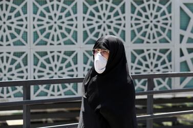 An Iranian woman covers her face as she walks down a street in Tehran. EPA