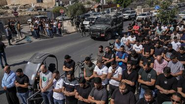 Palestinian worshippers pray outside Jerusalem's Old City while Israeli forces stand guard last October. AP