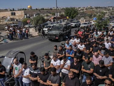 Palestinian worshippers pray outside Jerusalem's Old City while Israeli forces stand guard last October. AP