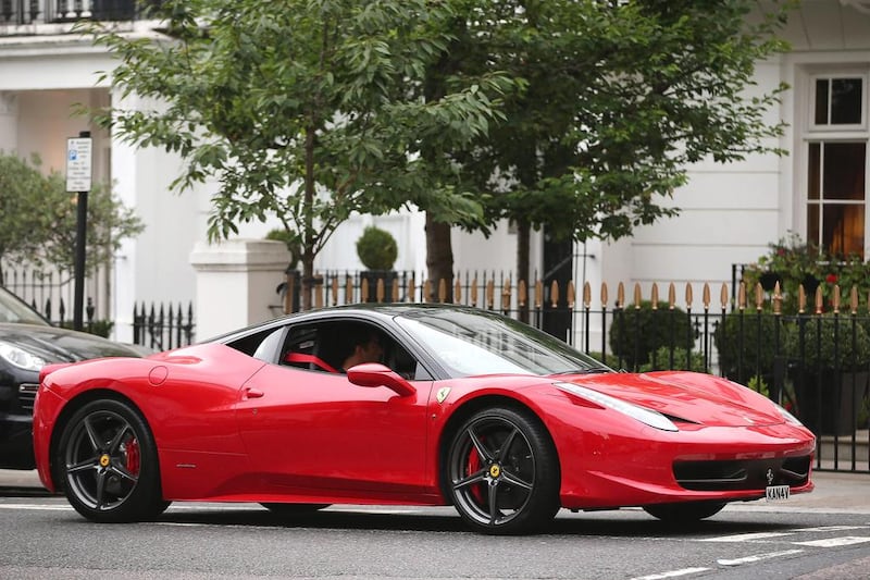 A Ferrari drives through Knightsbridge. Car enthusiasts have been flocking to the wealthy London district to see some of the world’s most expensive and extravagant supercars, many of them owned by wealthy Arab tourists escaping the summer heat back home. Dan Kitwood / Getty Images