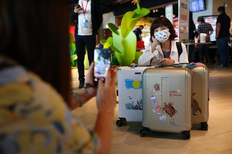 A traveller poses with luggage before the travel bubble flight to Palau, at Taoyuan International Airport in Taoyuan, Taiwan. Reuters