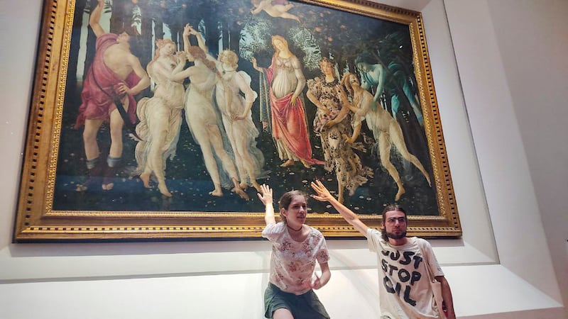 Two activists of the Ultima Generazione (Last Generation) environmentalist group glue themselves to the glass protecting Italian Renaissance painter Sandro Botticelli's 'Primavera (Spring)' in Florence's Uffizi Galleries on July 22. Photo: Ultima Generation via AP