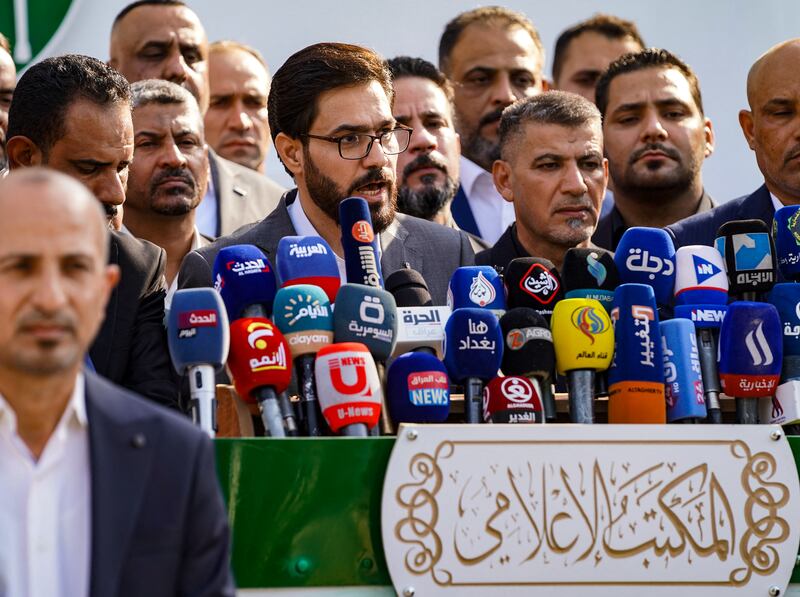 A member of the Iraqi Sadrist bloc (of Shiite leader Moqtada Sadr) announces the party's electoral programme for the upcoming elections, in the central city of Najaf, on September 30, 2021. - Iraq will hold parliamentary elections on October 10, a year early to appease an anti-government protest movement, at a time of simmering anger over graft and economic crisis. (Photo by Ali NAJAFI / AFP)