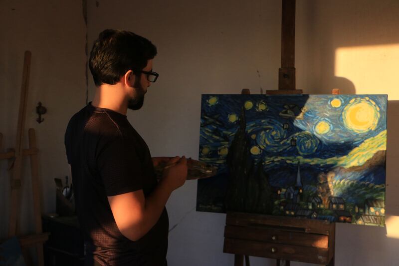 Al Shami puts the finishing touches to his picture based on Vincent Van Gogh’s 'The Starry Night'. Abd Almajed Alkahr/The National