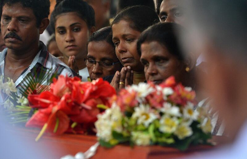 Mourners stand beside a coffin of a bomb blast victim. AFP