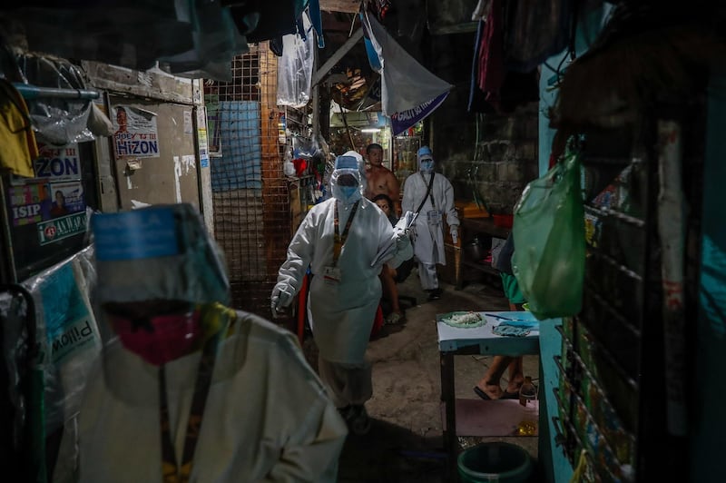 Health care workers enter an alley at night in Manila, Philippines,.  Four volunteer health workers were nicknamed 'Astronauts' by residents of Village 775, Zone 84 in Manila as they resemble such when donning their protective equipment. The healthcare volunteers conduct home visits twice a day to people infected or suspected to be infected with the novel SARS-CoV-2 coronavirus that causes the COVID-19 disease in one of the densely populated villages in Manila.  EPA