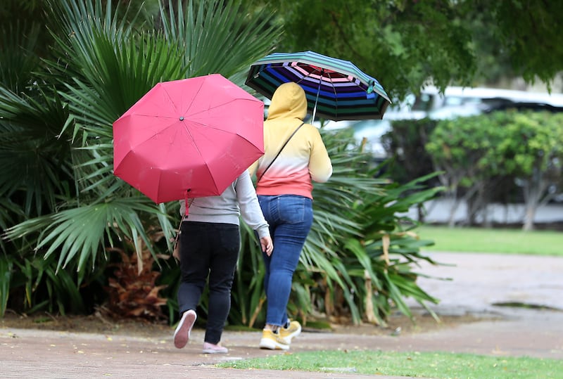 Not a common sight in the UAE, people using umbrella in the Discovery Gardens area in Dubai. Pawan Singh / The National