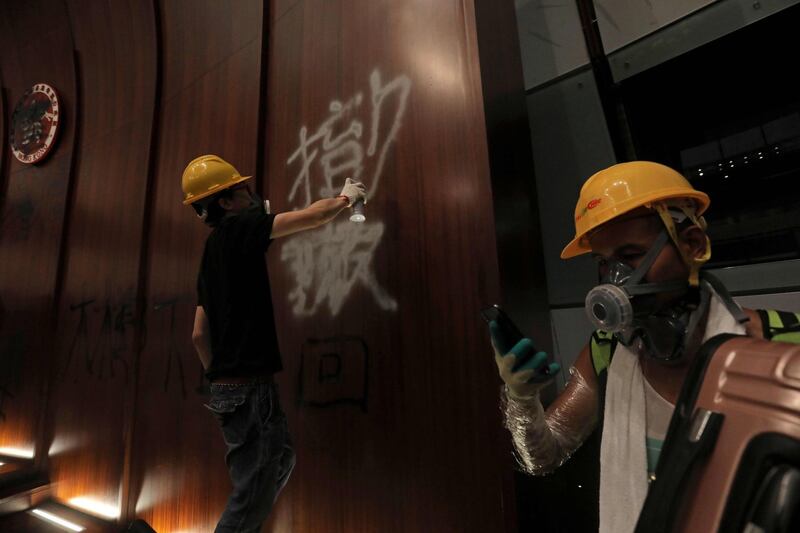 A protesters sprays graffiti onto the wall of the parliament chamber. AFP