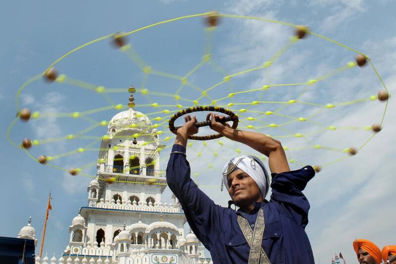 An Indian Nihang (religious Sikh warrior) shows off his skills during a procession from the Sikh Shrine Gurudwara Lohgarh Sahib to Gurudwara San Sahib at village Basarke, India. Narinder Nanu / AFP