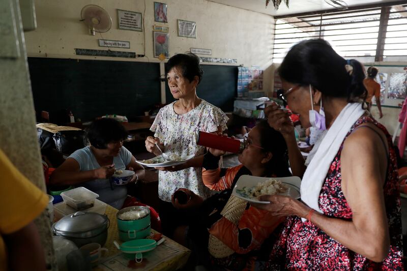 Residents who fled their homes eat in an evacuation centre in  the town of Laurel, Batangas province, Philippines.