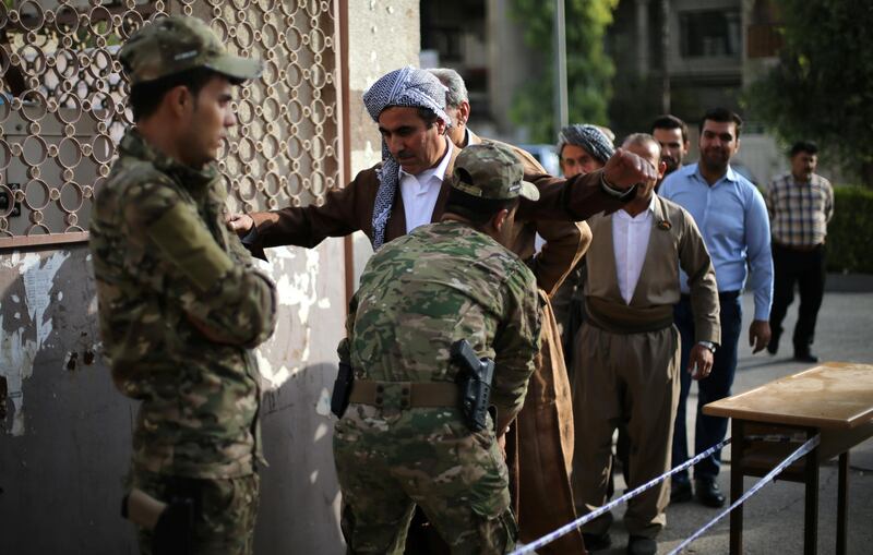 A man is checked by security before voting in Erbil. Ahmed Jadallah / Reuters
