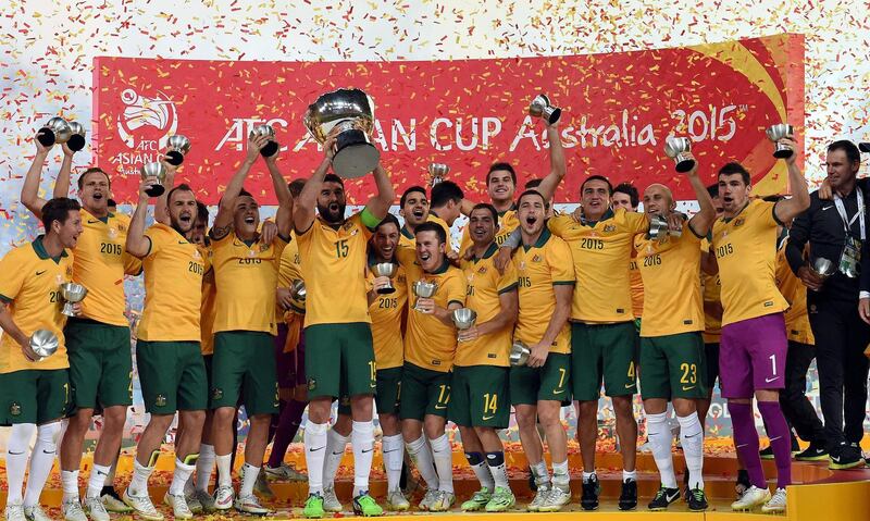 Australia's captain Mile Jedinak (5th L) holds up the AFC Asian Cup football trophy after beating South Korea at Stadium Australia in Sydney on January 31, 2015.   AFP PHOTO / Saeed KHAN 
-- IMAGE RESTRICTED TO EDITORIAL USE - STRICTLY NO COMMERCIAL USE / AFP PHOTO / SAEED KHAN