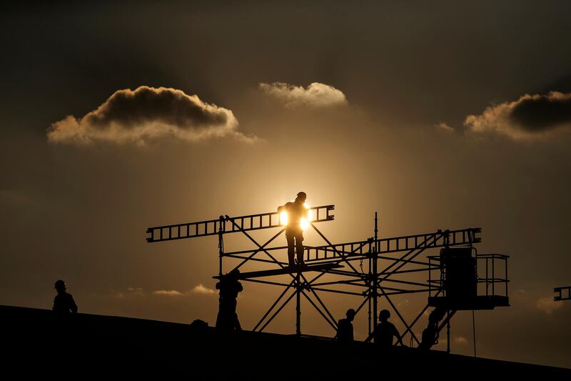 ABU DHABI, UNITED ARAB EMIRATES, Nov. 26, 2013:   
Men work constructing a scaffolding, silhouetted against the setting sun, at the Abu Dhabi National Exhibition Center in Abu Dhabi, on Tuesday, Nov. 26, 2013. (Silvia Razgova / The National)

Section: Focal Point
Reporter: standalone
Publishing: undated *** Local Caption ***  SR-131126-focalpoint03.jpg