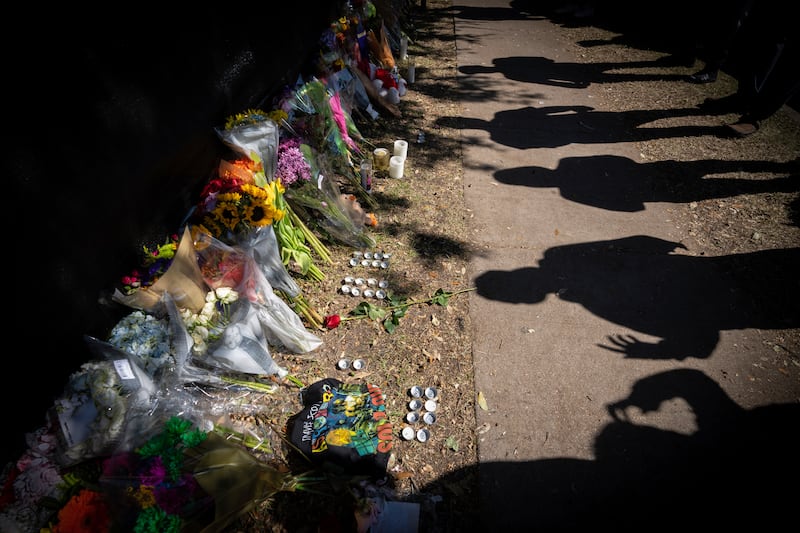 Visitors cast shadows at a memorial to the victims of the Astroworld concert in Houston on Sunday, November 7, 2021. Panic gripped concertgoers when they couldn't breathe and had no path to escape a massive crowd surge at the event. AP Photo
