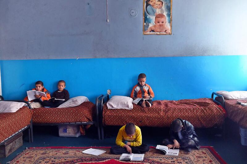 In this photograph taken on December 17, 2014, Afghan children read their school books as they sit in their bunk beds at the Halwdin government orphanage in Kabul. International aid was meant to transform Afghanistan's welfare standards, but orphanages in Kabul reveal that the most vulnerable children, many left parentless by war, have seen little benefit from the billions of dollars spent. Wakil Kohsar/AFP Photo

