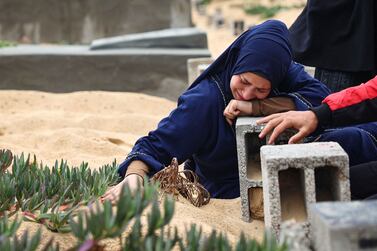 A woman cries over the grave of a loved one at the start of the Eid al-Fitr festival, marking the end of the Muslim holy month of Ramadan, at a cemetary in Rafah in the southern Gaza Strip, on April 10, 2024, amid the ongoing conflict between Israel and the militant group Hamas.  (Photo by AFP)