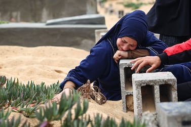A woman cries over the grave of a loved one at a cemetery in Rafah. AFP