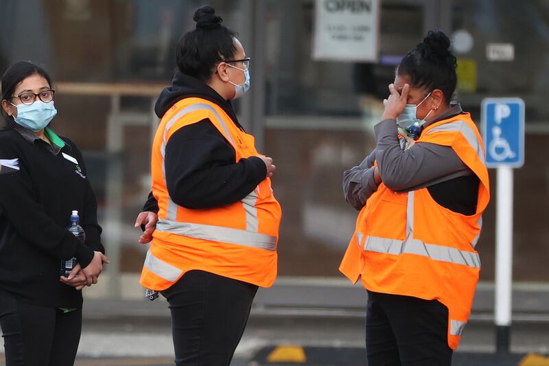 Countdown LynnMall staff comfort each other as they wait to leave with police after the attack. Getty Images