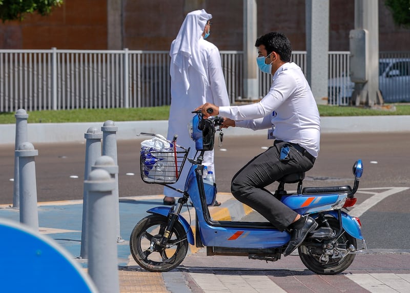 Abu Dhabi, United Arab Emirates, September 15, 2020.  The "new norm" of urban transportation is evident during the Covid-19 pandemic as a businessman hops on his e-scooter to get him mobile along the Corniche, Abu Dhabi.
Victor Besa /The National
Section:  NA/Stock Images
Reporter: