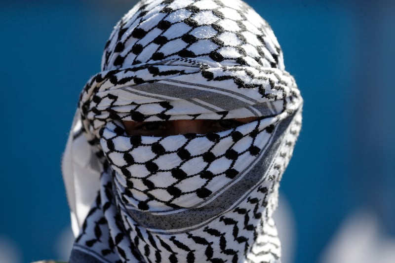 A newly-recruited member of the Houthis' popular army covering his face with a keffiyeh during a parade in Sana'a, Yemen. EPA