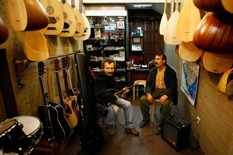 Recep Guclu on saz and Ali Cemdak sings at the Toprak Music store.Musical instrument stores located on Galip Dede Street by Beyoglu.