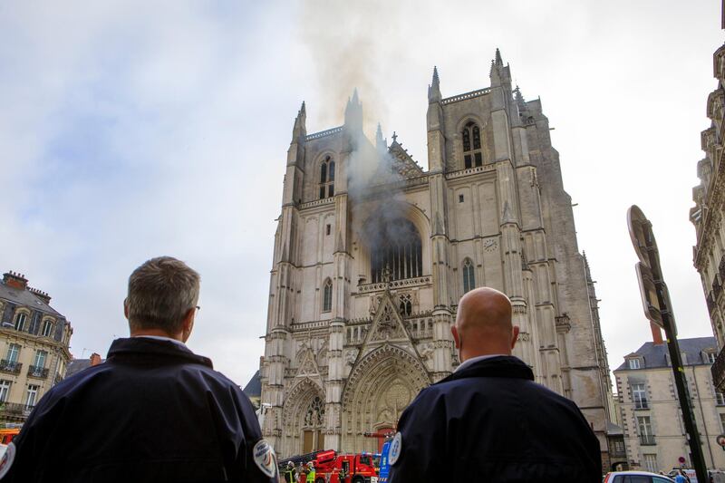 French police officers look at the blaze. AP Photo