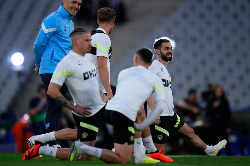 Manchester City's Bernardo Silva, right, warms up with his teammates during training. AP