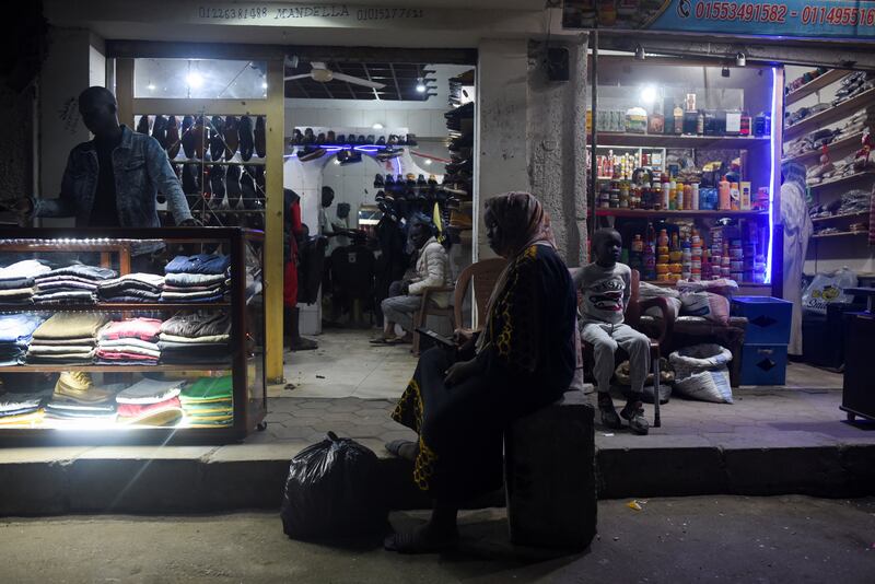 A woman sits outside Sudanese shops in Cairo. Reuters
