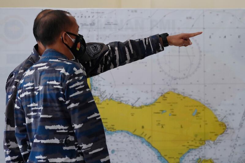 Military officers stand in front of a map of the search area for the missing Indonesian Navy submarine KRI Nanggala. EPA