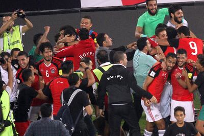 Egypt's team players celebrate wining against Congo's team during their World Cup 2018 Africa qualifying match between Egypt and Congo at the Borg el-Arab stadium in Alexandria on October 8, 2017.
Liverpool striker Mohamed Salah converted a stoppage-time penalty to give Egypt a dramatic 2-1 win over Congo Brazzaville Sunday and a place at the 2018 World Cup in Russia. / AFP PHOTO / TAREK ABDEL HAMID