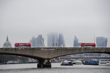 Near-empty buses cross Waterloo bridge during lockdown with skyscrapers of the city of London financial district seen. UK finance minister Rishi Sunak said November's GDP contraction indicates “things will get harder before the get better”. Reuters