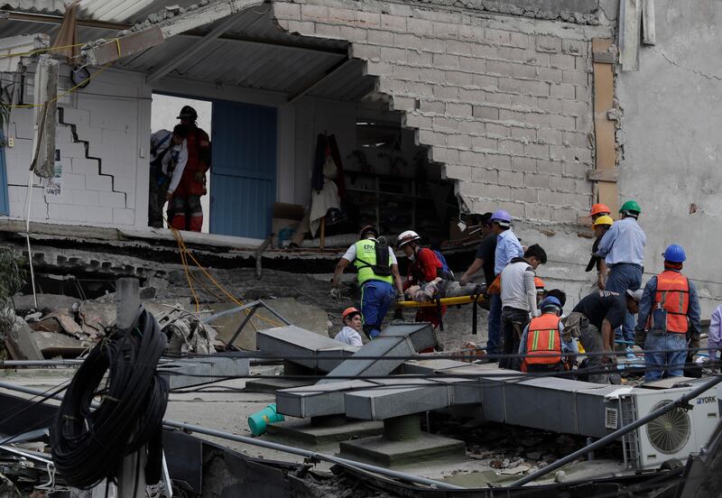 An injured woman is carried out of a building that collapsed during an earthquake in Mexico City. Rebecca Blackwell / AP Photo