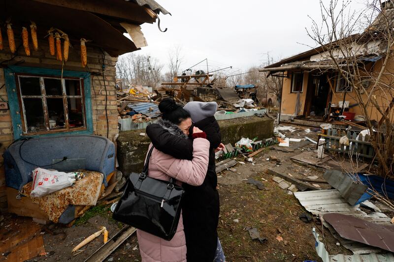 A resident embraces a friend next to her mother's house which was damaged during a Russian missile strike in Kyiv, Ukraine.  Reuters
